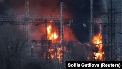 Дим і вогонь видно навколо високовольтних ліній на місці російського ракетного удару поблизу Харкова, 22 березня 2024 року