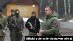 Намесьнік міністра ўнутраных справаў, камандуючы ўнутранымі войскамі МУС Беларусі Мікалай Карпянкоў на вучэньнях унутраных войскаў зь нестатутным шаўронам, чки нагадвае знак ПВК «Вагнэр». Архіўнае фота