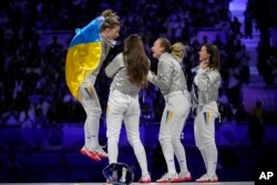Харлан (слева) и её коллеги по команде празднуют свою победу в Париже. 3 августа 2024 года