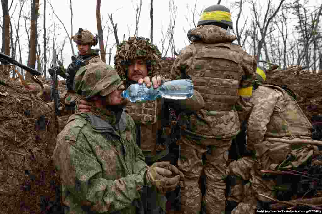 Бахмуттун жанында колго түшкөн орус аскерине украиндер суу жуткуруп жатат, 2023-жылдын май айы. 
