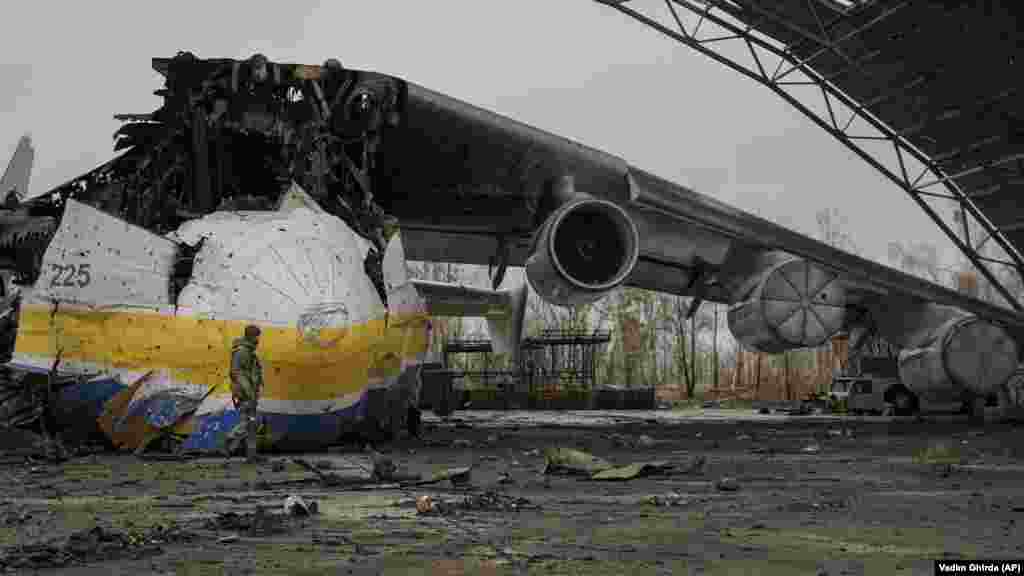 Український військовослужбовець біля залишків найбільшого у світі транспортного літака Ан-225 «Мрія». Літак був знищений російським ударом 27 лютого під час боїв в аеропорту Антонова в Гостомелі. «Мрія» любили ентузіасти авіації у всьому світі. Літак використовувався, зокрема, для перевезення гуманітарних вантажів. Фото від 2 квітня 2022 року