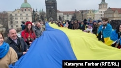 Украинцы разворачивают флаг своей страны на Карловом мосту в Праге 19 января 2025 года