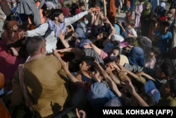 Porodice koje su pobjegle iz Kunduza i provincije Takhar zbog borbi između talibana i afganistanskih snaga sigurnost u redu za hranu, u Kabulu 9. augusta 2021.