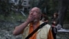 Утро 17 июня. Киевлянин смотрит на один из домов, разрушенных в результате российского удара