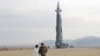 Lider Severne Koreje sa kćerkom na nepoznatoj lokaciji, iza njih je interontinentalna balistička raketa