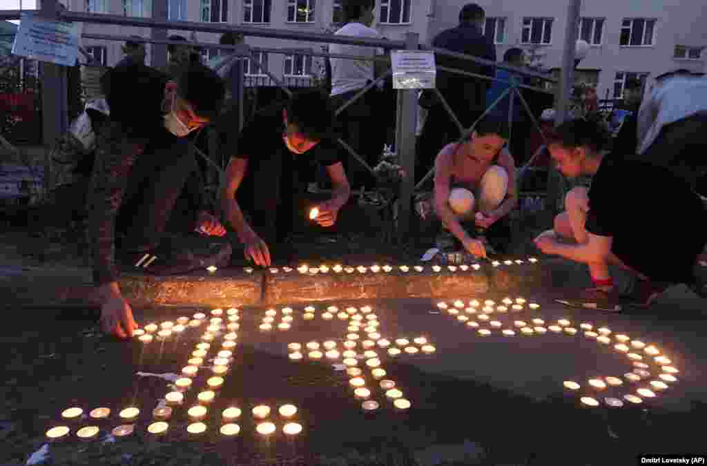 Люди ставлять запалені свічки на землю, щоб сформувати номер 175 школи в Казані, 11 травня