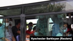 Türkmenistanda jemgyýetçilik awtobusynda sapar edýän ýüzi maskaly ýolagçylar. Illýustrasiýa suraty
