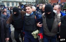 Пророссийские боевики после штурма выводят из помещения начальника милиции Горловки Андрея Крищенко, не давшего установить на РУВД российский флаг, 14 апреля 2014 года