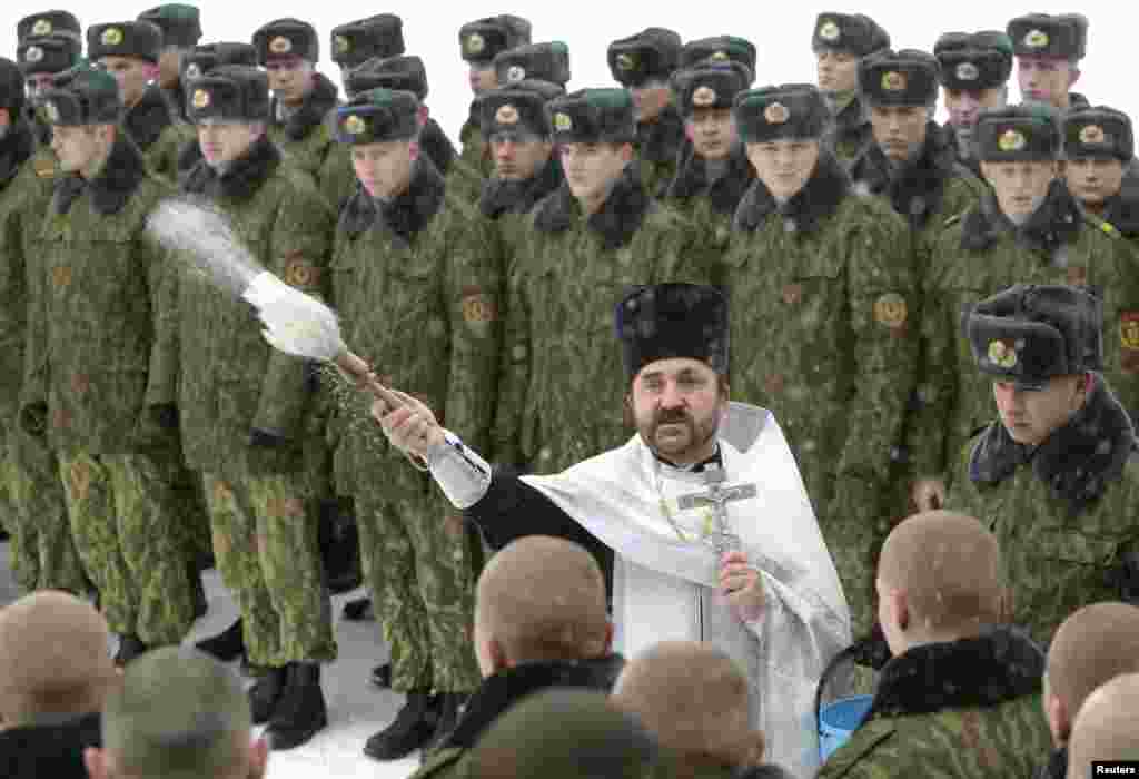 Беларусь. Священник окропляет святой водой