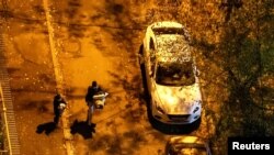 Žena nosi ćebe i jastuk dok trči u sklonište s detetom koje drži igračku tokom ruskog raketnog udara u Kijevu rano 17. novembra 2024.