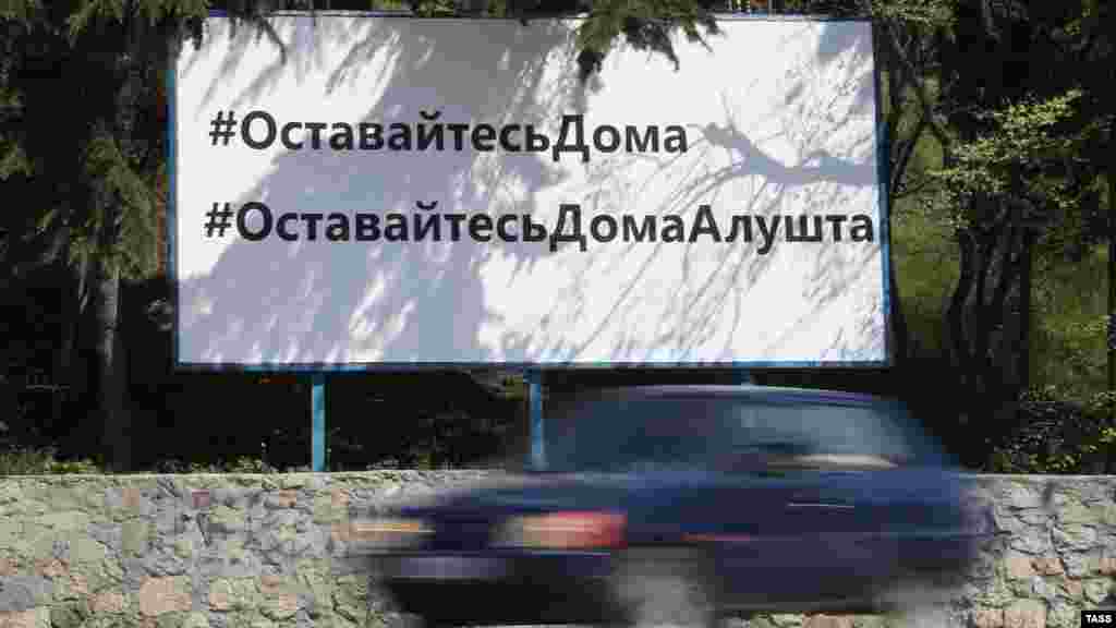 В Алушті закликають залишатися вдома (банер на узбіччі дороги)