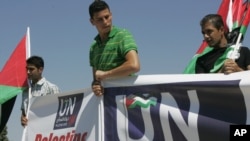 Günbatar Kenardaky Ramallah şäherinde palestin aktiwistleri BMG-niň edarasyna bu gurama agza döwlet bolmak baradaky ýüzlenmelerini gowşuranlaryndan soň, ellerine plakatlary göterip çykyş etdiler. Ramallah. 8-nji sentýabr, 2011.