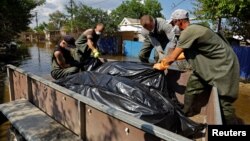 Доброволци и общински служители изваждат тела от наводнени къщи в засегнатия от наводнението район