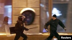 Polisiýa işgäri demonstranty kowalaýar, Minsk, 2010-njy ýylyň 19-njy dekabry.