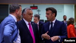 Премьер-министр Венгрии Виктор Орбан (второй слева) и президент Франции Эммануэль Макрон (справа) на саммите ЕС, 30 мая 2022 года