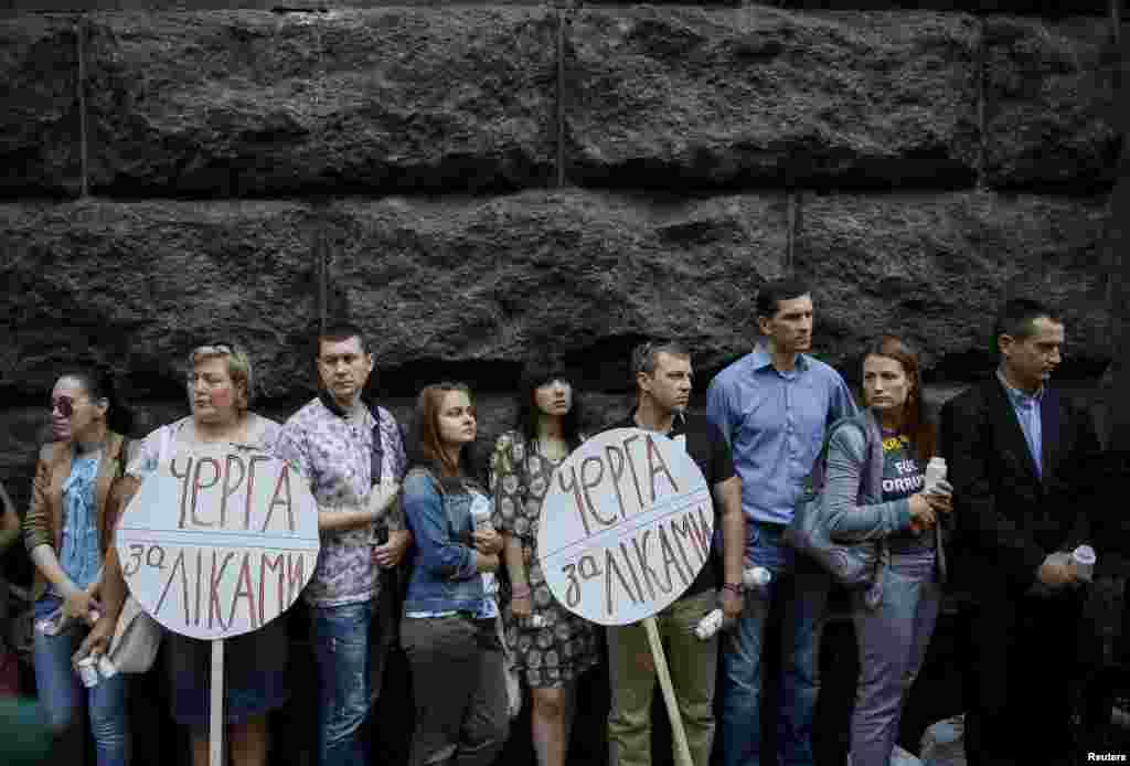 Учасники акції «Черга за лікуванням у Кабмін. 30 тисяч смертельно хворих залишили без лікування». Учасники заходу висловили занепокоєння з приводу того, що Міністерство охорони здоров'я України не закупило ліки, а Кабінет Міністрів України не проконтролював виконання державних програм з лікування, через що 30 тисяч ВІЛ-інфікованих українців залишилися без необхідних ліків. Київ, 1 липня 2015 року.