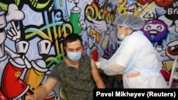 Алматыдагы соода борборлордун биринде ачылган эмдөө борборунда коронавируска каршы вакцина алып жаткан жаран. 27-апрель, 2021-жыл.
