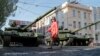 Донеччанка переходить вулицю Артема в Донецьку перед танками бойовиків на репетиції параду до 9 травня

